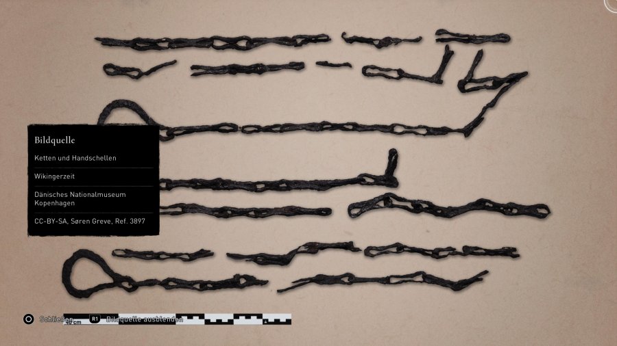 Eine Sammlung archäologischer Funde aus der Wikingerzeit. Zu sehen sind Metallketten und Teile von Handschellen.