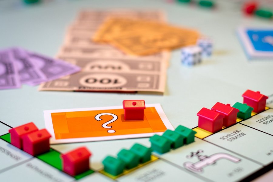 Ein Spielfeld. Das Brettspiel Monopoly. Es liegt viel Geld auf dem Tisch.