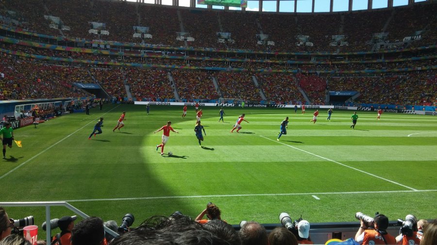 Das Bild zeigt einen Screenshot des Games FIFA. Dabei laufen Fußballspieler über den rasenplatz im Stadion und spielen gegeneinander.